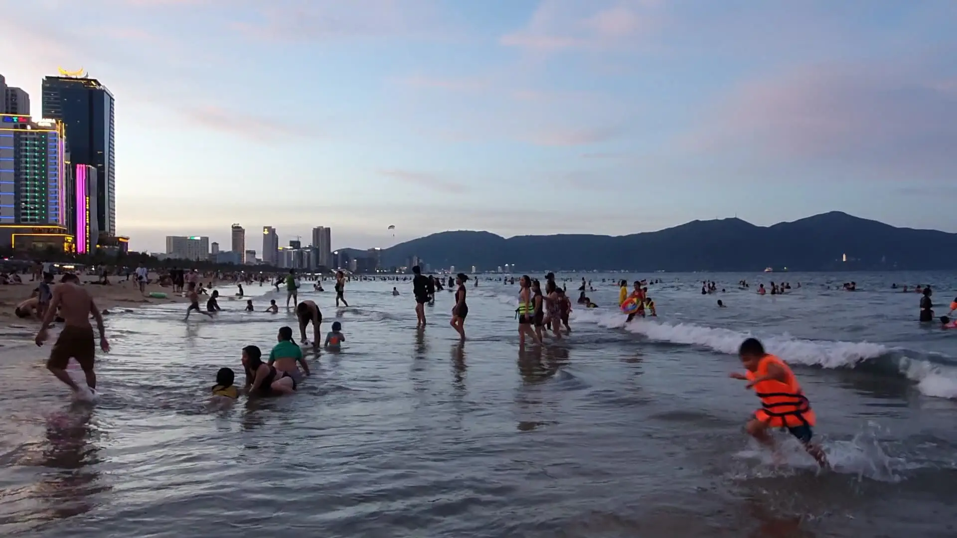 A parent supervising children playing on the sand at My Khe Beach