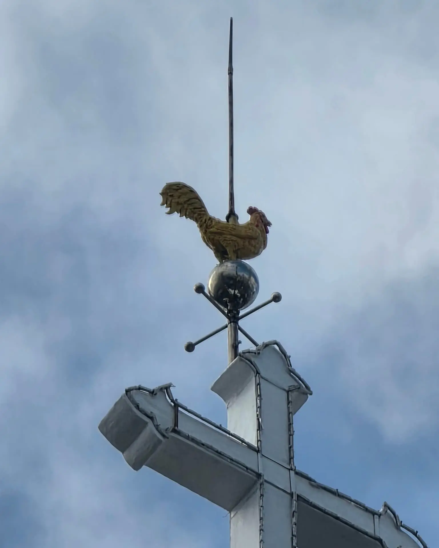 Metal rooster weather vane above the pointed tower of Da Nang Cathedral